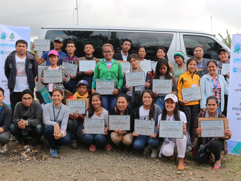 Survey practicum participants poses, while holding their certificate of completion, together with the facilitators, for the last part of the training.