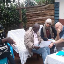 The delegation from the Embassy of the Kingdom of Netherlands in Uganda assess a Certificate of Customary Ownership as Ms. Sarah Tushabomwe from Nyabyumba village, Kamuganguzi Sub county- Kabale District, co-owner of the document, looks on.