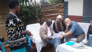 The delegation from the Embassy of the Kingdom of Netherlands in Uganda assess a Certificate of Customary Ownership as Ms. Sarah Tushabomwe from Nyabyumba village, Kamuganguzi Sub county- Kabale District, co-owner of the document, looks on.