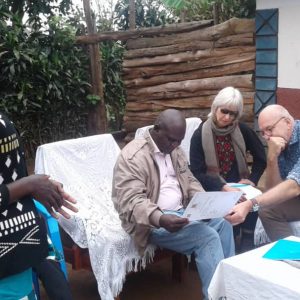 The delegation from the Embassy of the Kingdom of Netherlands in Uganda assess a Certificate of Customary Ownership as Ms. Sarah Tushabomwe from Nyabyumba village, Kamuganguzi Sub county- Kabale District, co-owner of the document, looks on.