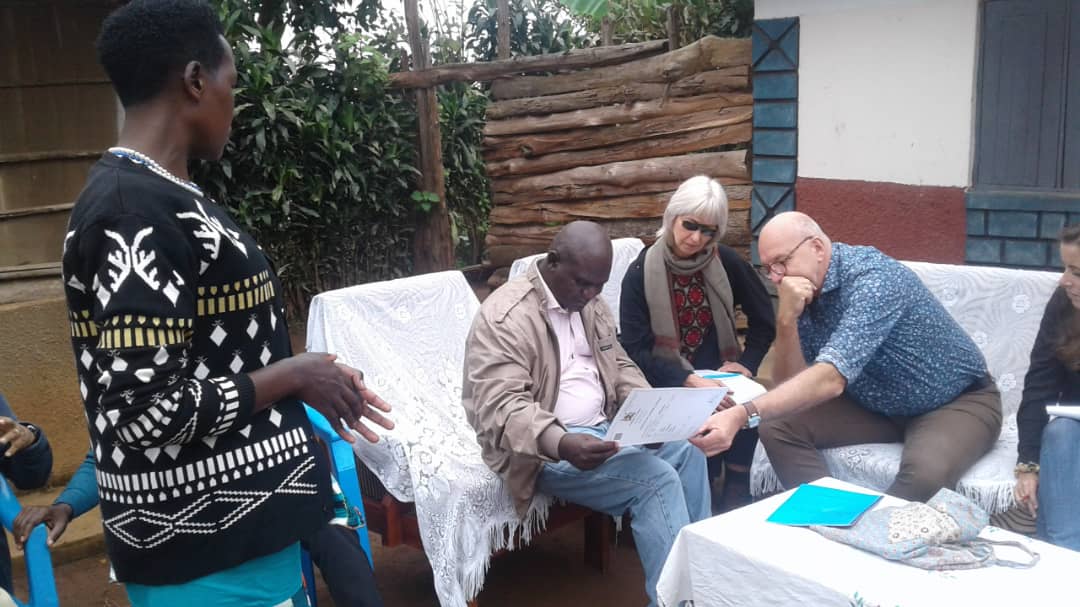 The delegation from the Embassy of the Kingdom of Netherlands in Uganda assess a Certificate of Customary Ownership as Ms. Sarah Tushabomwe from Nyabyumba village, Kamuganguzi Sub county- Kabale District, co-owner of the document, looks on.