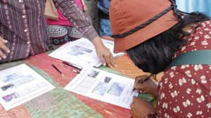 A neighbor representative signs a certificate during the award ceremony in July 2020
