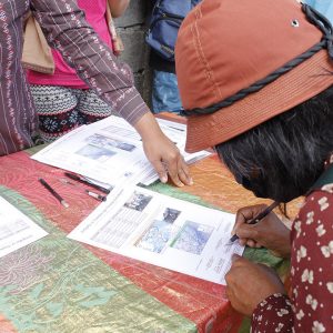 A neighbor representative signs a certificate during the award ceremony in July 2020