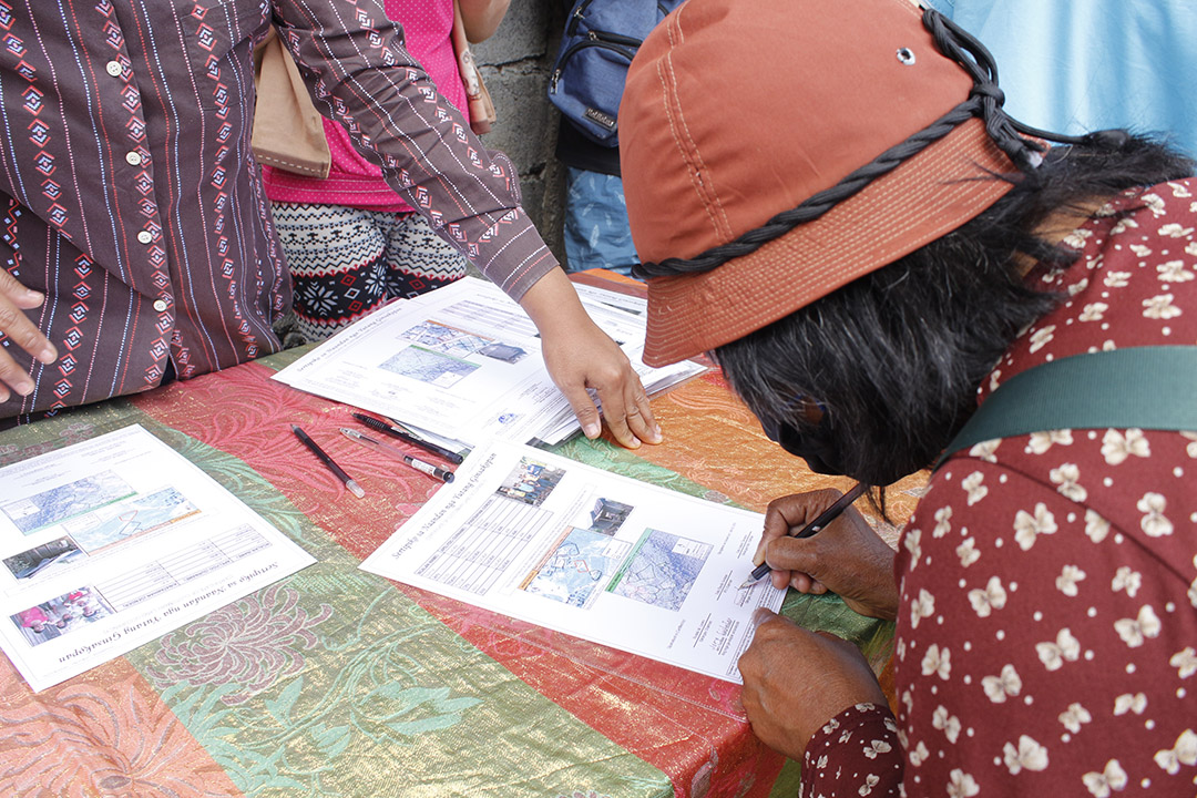 A neighbor representative signs a certificate during the award ceremony in July 2020
